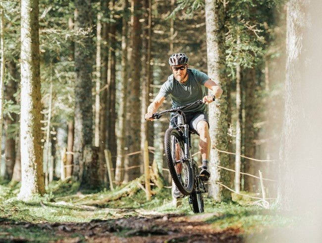 Hermann Maier beim Mountainbiken im Wald © Flachau Tourismus